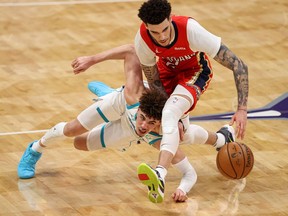 Brothers Charlotte Hornets guard LaMelo Ball (left) and New Orleans Pelicans guard Lonzo Ball fight for a loose ball in the fourth quarter at Spectrum Center.