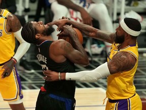 LA Clippers guard Paul George (13) is fouled by Los Angeles Lakers forward Markieff Morris (88) in the second half at Staples Center in Los Angeles on May 6, 2021.