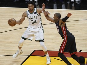 Milwaukee Bucks forward Giannis Antetokounmpo controls the basketball against Miami Heat forward Andre Iguodala during the fourth quarter of game four in the first round of the 2021 NBA Playoffs at American Airlines Arena.