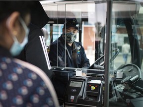 A Transit Windsor bus driver sits behind a protective plastic shield while he waits for passengers to embark outside the Windsor International Transit Terminal, Oct. 26, 2020. Fares are increasing by a nickel on July 1.