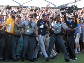Phil Mickelson is assisted by security as he is followed up the 18th fairway by a gallery of fans after hitting his approach shot during the final round of the 2021 PGA Championship held at the Ocean Course of Kiawah Island Golf Resort on May 23, 2021 in Kiawah Island, South Carolina.