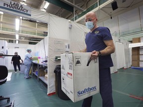 Pharmacist David Sinewitz is shown with a shipping container that is used to ship the Pfizer-BioNTech COVID vaccine on Monday, May 3, 2021 at the St. Clair College SportsPlex field hospital.