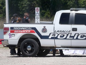 LaSalle police officers stand near the body recovered from the Detroit River on May 30, 2021.