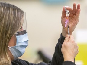Jill Seara, a public health nurse loads a 1ml syringe with the Pfiizer COVID-19 vaccine at the Caradoc community centre in Mt. Brydges, west of London.