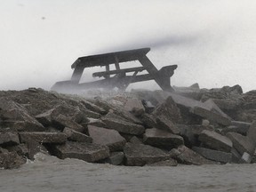 Waves hit a picnic table on a break wall on January 16, 2020, in Lighthouse Cove.
