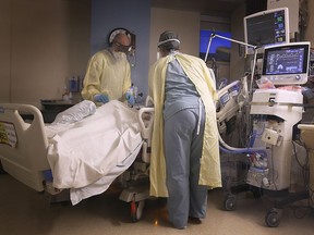 In this Jan. 18, 2021, file photo, nursing staff attend a COVID-19 patient at Windsor Regional Hospital's Met campus intensive care unit.