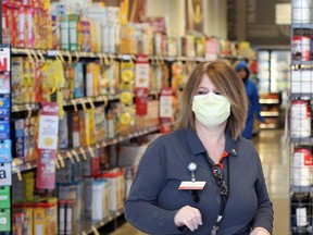 Laurie Cornellier, an employee at the Metro grocery store in the Devonshire Mall in Windsor, works in the self-checkout area in April 2020.