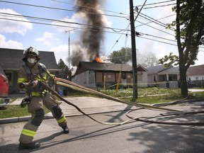 Ein Feuerwehrmann aus Windsor streckt am Freitag, den 7. Mai 2021, einen Schlauch am Brandort eines verlassenen Hauses im Block 3500 der Peter Street.