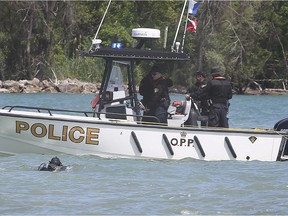 An OPP diver is shown Thursday, March 27, 2021, searching for the body of a man who went swimming and then missing near Sand Point Beach in Windsor on the weekend.