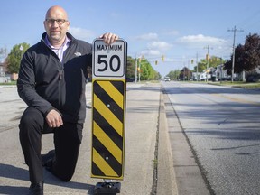 Phil Bartnik, director of public works and environmental services for the Town of Tecumseh, is pictured Friday with one of the flexible road signs that are being installed in the middle of roads to curb speeding.