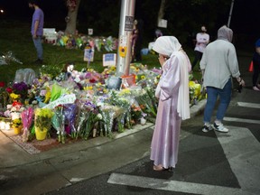 Members of the Muslim community and supporters light candles and place flowers at a memorial on June 8, 2021 in London. A vigil was held earlier in the day, following a vehicular terror attack that left four members of a local Muslim family dead and a nine-year-old boy clinging to life in a local hospital.