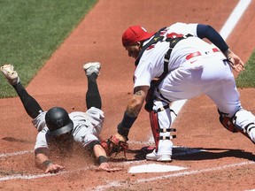 Jon Berti of the Miami Marlins is tagged out at home by Yadier Molina of the St. Louis Cardinals in the in the fourth inning of a game between the St. Louis Cardinals and the Miami Marlins at Busch Stadium on June 16, 2021 in St Louis, Missouri.