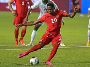 Jonathan David #20 of Canada scores his third goal of the match on a penalty kick against Suriname during a FIFA World Cup Qualifier at SeatGeek Stadium on June 08, 2021 in Bridgeview, Illinois.