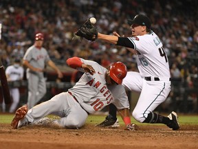 Justin Upton of the Los Angeles Angels slides safely into home plate as the throw from Carson Kelly of the Arizona Diamondback gets away from Taylor Clarke during the seventh inning at Chase Field on June 11, 2021 in Phoenix, Arizona. The ruling was a wild pitch by Clarke.