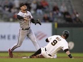 Josh Rojas of the Arizona Diamondbacks throws to first base over Brandon Belt of the San Francisco Giants but not in time to complete the double play in the bottom of the fourth inning at Oracle Park on June 15, 2021 in San Francisco, California. Donovan Solano was safe at first base on the play.
