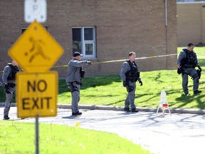 Windsor Police Service ESU members search for evidence following a homicide outside Dr. Roy Perry Apartment complex at 395 University Avenue East on May 13, 2020.