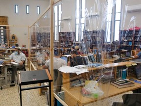 Israeli Yeshiva (Jewish educational institution for studies of traditional religious texts) students are picture at their learning centre separated by plastic barriers to insure that social distancing measures imposed by Israeli authorities meant to curb the spread of the novel coronavirus are being respected, in Tel Aviv on July 7, 2020.