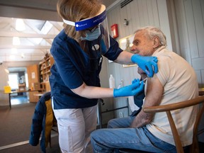 A health worker vaccinates an elderly man with the Biontech-Pfizer Covid-19 vaccine at a temporary vaccination clinic in a church in Sollentuna, north of Stockholm on March 2, 2021.