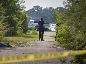 Windsor police hold a scene behind yellow police tape near the Detroit River at the base of Mill Street, on Wednesday, June 9, 2021.
