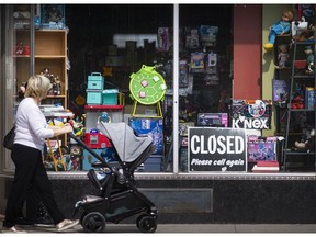 WINDSOR, ONTARIO:. APRIL 7, 2021 - Pedestrians walk by a closed Holland Consignment Shoppe & Auction House on Ottawa Street on the eve of a province wide stay-at-home order on Wednesday, April 7, 2021.