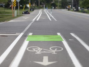 Neon green paint and temporary bollards are seen along Old Tecumseh Road as part of the County Wide Active Transportation System pilot project, on Wednesday, June 9, 2021.