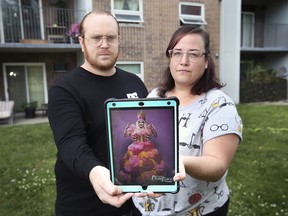 John Reh and Britt Leroux pose with an image of Jimbo, a drag queen that the couple wanted placed on a cake. A local company refused the request.