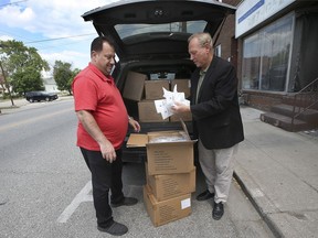 Khassan Saka, president of the Integrative Canadian Group Organization, left, helps Larry Horwitz, chair of the Wyandotte Town Centre BIA load approximately 3,000 masks and gloves on Tuesday, June 1, 2021. The organization donated the PPE to the BIA who will in turn distributed them to local merchants.