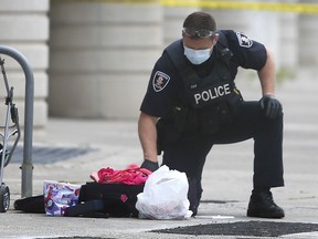 Windsor Police shut down Chatham Street in front of their headquarters on Wednesday, June 2, 2021 for an hour and a half after a suspicious package was found on the sidewalk. The department's explosive disposal unit was called out to check out the package and determined it was not a threat. An officer checks out items in a suit case type container during the incident.