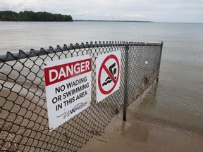 A sign warning beachgoers not to swim in a fenced-off section of Sandpoint Beach in Windsor is seen on Monday, June 7, 2021.