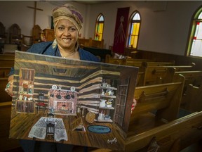 Standing on the shoulders of ancestors. Lana Talbot, heritage coordinator for the Sandwich First Baptist Church, is shown on Tuesday, June 29, 2021, holding a painting of what the future Underground Railroad Museum might look like.