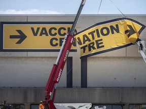 Crews put up new Vaccination Centre signs on the former Sears building at Devonshire Mall, on Wednesday, June 16, 2021. Dr. Wajid Ahmed, the medical officer of health, says a two-dose summer could become reality.