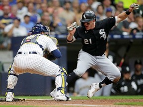 Zack Collins of the Chicago White Sox pulls up short at home plate before being tagged out running back to third base by Omar Narvaez of the Milwaukee Brewers in the seventh inning at American Family Field on July 23, 2021 in Milwaukee, Wisconsin.