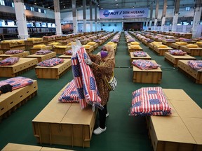 Workers prepare mattresses and blankets for some 1,800 cardboard beds at a COVID-19 field hospital inside a warehouse at the Don Mueang International Airport in Bangkok on July 27, 2021, as shortages for beds for infected patients continues across the nation.