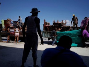 People load trucks with furniture to be relocated prior to the arrival of Storm Elsa, in Havana, Cuba, Sunday, July 4, 2021.