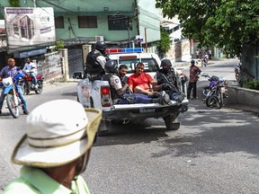 Two men, accused of being involved in the assassination of President Jovenel Moise, are being transported to the Petionville station in a police car in Port-au-Prince, Thursday, July 8, 2021.