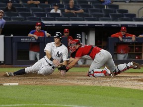 New York Yankees first baseman DJ LeMahieu is tagged out at home on a fielders choice by Philadelphia Phillies catcher J.T. Realmuto  during the ninth inning at Yankee Stadium.