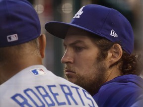 Los Angeles Dodgers starting pitcher Trevor Bauer (R) talks with Dodgers manager Dave Roberts (L) in the dugout against the Washington Nationals in the third inning at Nationals Park.