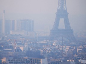 FILE PHOTO: The Eiffel Tower is surrounded by a small-particle haze which hangs above the skyline in Paris, France, December 9, 2016 as the City of Light experienced the worst air pollution in a decade.