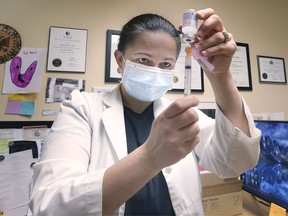 "Almost like a calling." Dr. Magbule Doko prepares a dose of the Moderna COVID-19 vaccine on Friday, July 9, 2021, at the Howard Medical Clinic.