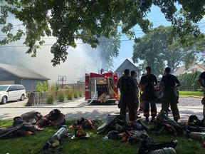 Firefighters with the Kingsville and Leamington fire departments attend the scene of a house fire on Orchard Boulevard in Kingsville on July 27, 2021.