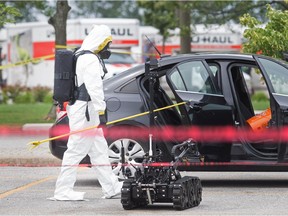 A member of the Windsor Police Service explosive disposal unit investigates a possibly hazardous material inside a car parked in the 8500 block of Tecumseh Road East on Tuesday, July 13, 2021.