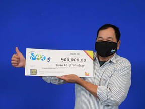 Xuan Nguyen, 59, of Windsor, accepts his $500,000 prize cheque from winning Maxmillions on a Lotto MAX draw.