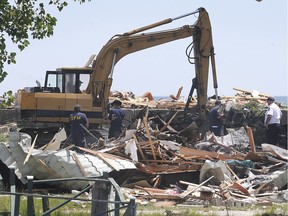 Fire investigators sift through the debris at Marentette Beach in Leamington on July 15, 2020, days after an explosion destroyed a home and killed two occupants.