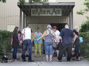 A group of people participate in a prayer circle at the River Place apartments on Wednesday, July 21, 2021. Several individuals were evicted from the building after the city deemed it unsafe.