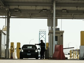Customs and Border Protection agents watch over vehicles reentering the U.S. from Canada, which has opened its borders to U.S. citizens who can provide proof of vaccination and a negative COVID-19 test, at the Ambassador Bridge Port of Entry of Entry August 9, 2021 in Detroit, Michigan. The border had been closed to non-essential travel since March 2020.