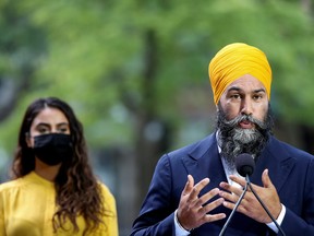 Jagmeet Singh speaks to the press as his wife, Gurkiran Kaur Sidhu, looks on, in Montreal on Aug. 15, 2021.