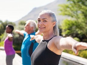 Senior woman stretching arms in yoga class