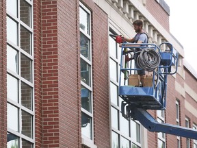 A worker prepares to seal new windows at the David Maxwell Public School in Windsor on Wednesday, August 18, 2021.