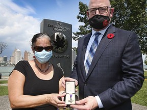 Madelyn Della Valle, curator at Museum Windsor and Windsor Mayor Drew Dilkens are shown on Thursday, August 19, 2021 with a war medal of a local solider killed during the Dieppe raid. A ceremony marking the 79th anniversary of the disastrous Dieppe Raid was held at the Dieppe Park.