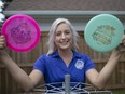 Chantel Budinsky, who came in third in the  PDGA Amateur World Championships, poses with two discs from the event, while practicing in her backyard on Tuesday, August 24, 2021.